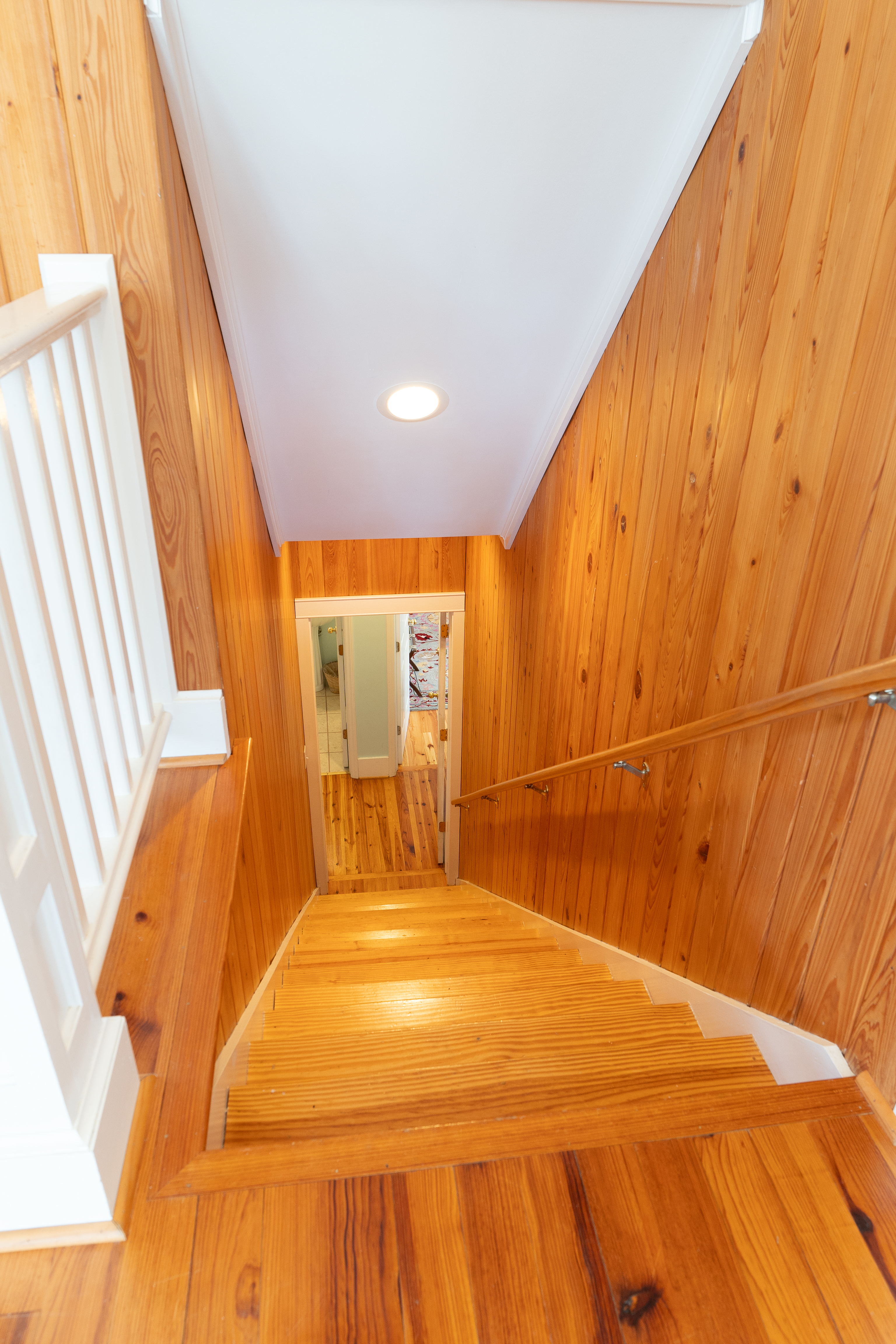 The heart-pine stair and paneled stairwell, worked by hand during the restoration