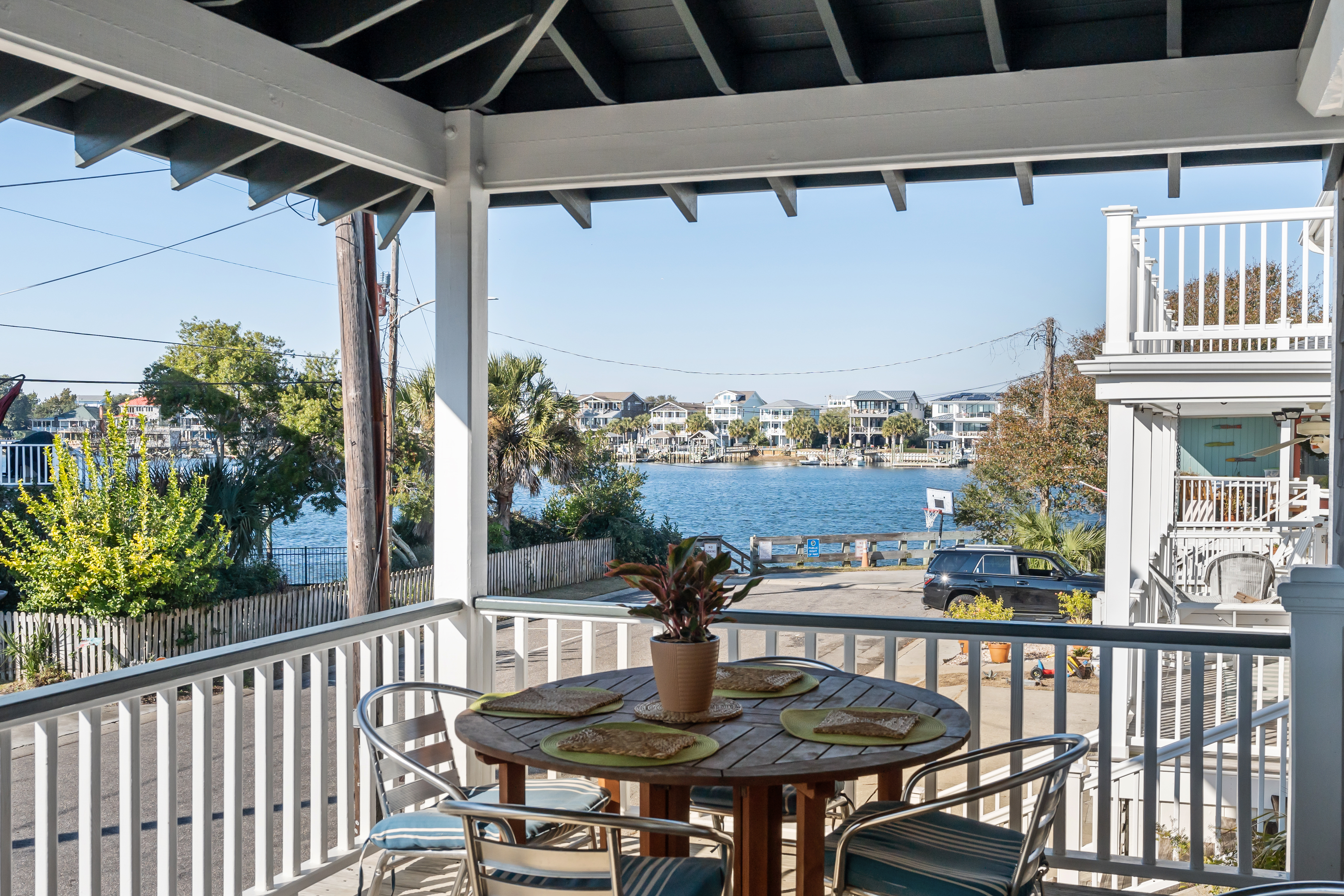 The covered porch table set for dinner, looking straight out over Banks Channel